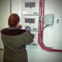Técnico realizando revisión de sistema de detección de incendios en Garaje